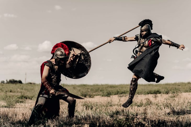 Battle with spear and sword between two ancient warriors in battle dress